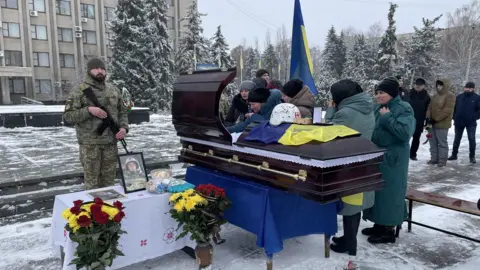 BBC/Ed Habershon Image of people gathered around a coffin at Denys Sosnenko's funeral