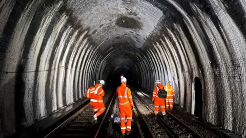 Network Rail The Blackheath tunnel inspected by four men in orange jacket