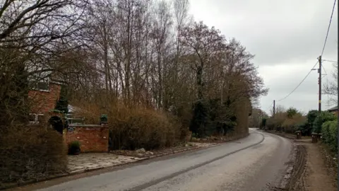 Spiby's red brick cottage on a country lane with few houses 