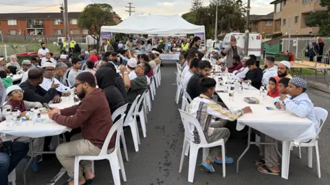 People gather for a community iftar at the Imam Ali bin Abi Taleb Mosque