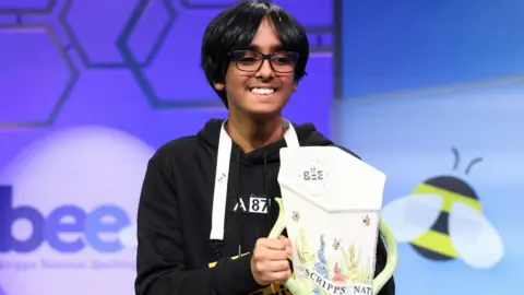 Faizan Zaki holding the 2025 Scripps National Spelling Bee trophy