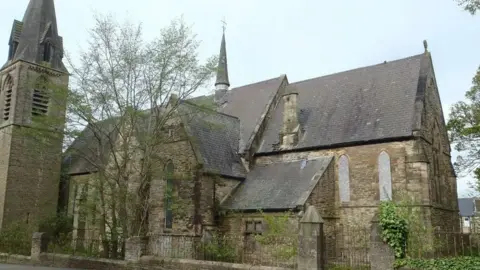 A view of St Aidan's Church in Blackhill, near Consett, County Durham. The church's window's are boarded up, and tiles are visibly missing from the roof. 