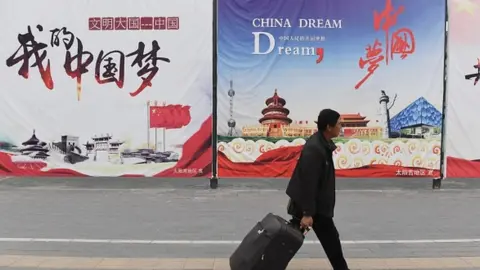 AFP A man walking past 'The China Dream' posters