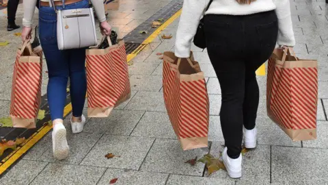 PA Media shoppers carrying bags on high street