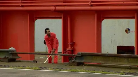 Crew member playing cricket