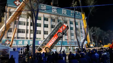 AFP Rescuers lift a bus out of a sinkhole