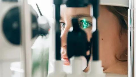 Close up of a young person's face with an eye being examined by technical equipment