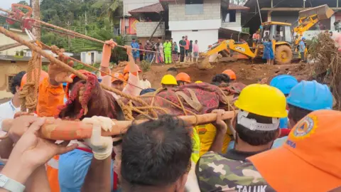 Rescuers pull out bodies from the debris