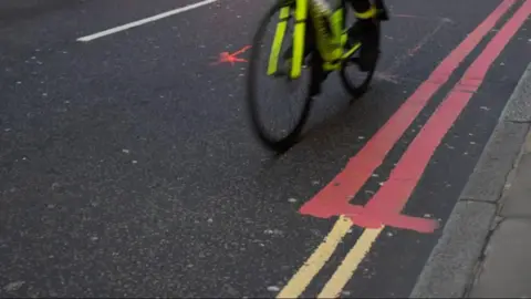Getty Images Red route and double yellow lines pictured with a bike (generic image)