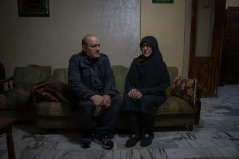 Joel Gunter/BBC Rihab’s father Muhieddine and mother Basima in their apartment in Beirut. “Rihab has experienced immense pain,” Basima said.