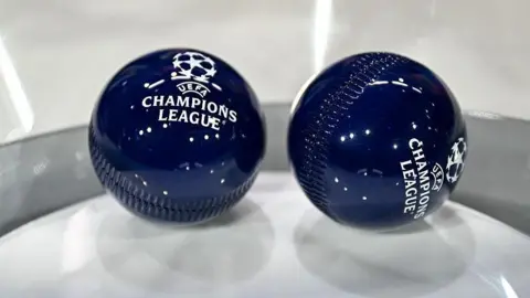 This photograph shows the draw balls bearing the Champions League logo