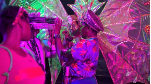 Anna de Escobar Symone altering costume behind the scenes of film