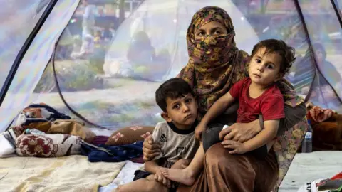 Getty Images A displaced family in a tent at a makeshift camp in Kabul