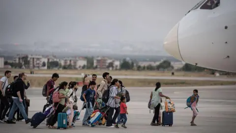 Getty Images Passengers board another flight that landed in Erzurum, Turkey after their Vistara Airlines flight from India to Germany made an emergency landing at Erzurum Airport due to a bomb threat, on September 7, 2024.