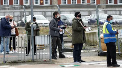 Reuters People queue for tests in Bolton