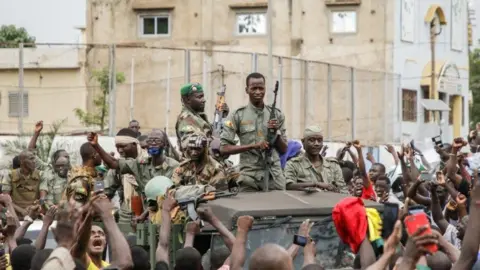 Getty Images Armed members of the FAMA (Malian Armed Forces) are celebrated by the population as they parade at Independence Square in Bamako on August 18, 2020.