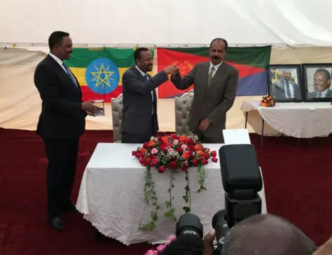 Kalkidan Yibeltal/BBC Ethiopia's Prime Minister Abiy (C) handed the key to the embassy to Eritrea's President Isaias