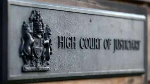 Sign outside building which says HIGH COURT OF JUSTICIARY in bold letters.