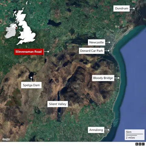 A map of the County Down area. The Slievenaman Road is displayed in pin in red. Other areas in the map include Bloody Bridge, Newcastle, and Spelga Dam. The sea is to the right. A mountainous area is in the centre. 