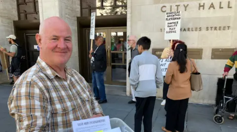 A man standing outside City Hall in Leicester