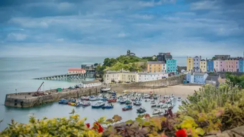 Multi-coloured frontages of properties overlooking Tenby harbour