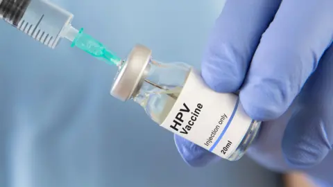 Getty Images Somebody withdrawing HPV vaccine from the bottle