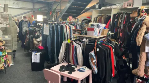 The interior of Sophie's Journey Preloved Charity Shop in North Hykham with rails of clothes