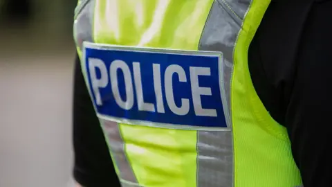 A general view of the back of a police officer who is wearing a hi-vis jacket.