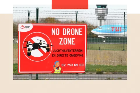 Reuters An aircraft lands on the tarmac near a "No Drone Zone" placard 
