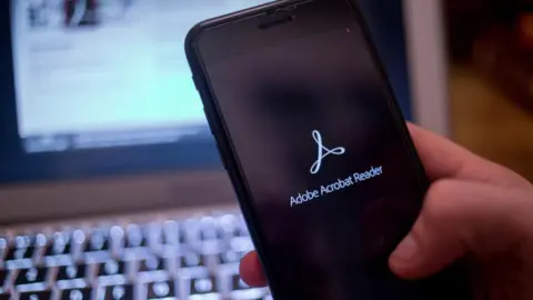 In this photo illustration, the Adobe Acrobat Reader application seen displayed on a iPhone.