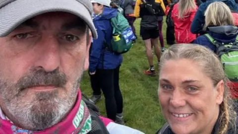 Dave McMullan and Kim Whitehead pictured at a previous event. McMullan is wearing a grey cap and has a beard. Whitehead has long fair hair and is smiling.