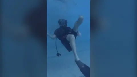 Man wearing scuba diving equipment in swimming pool