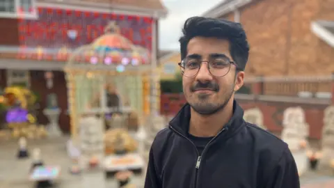 Mr Gohil's son Jaimi pictured outside the house that has been decorated for Diwali. There are hundreds of lights on the house. 