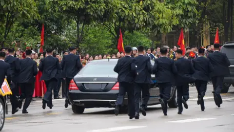 AFP Bodyguards running next to a limousine