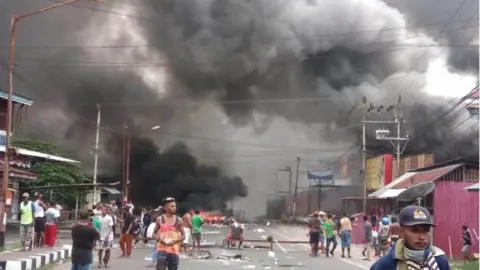 AFP Large clouds of smoke are see amid debris and fire on the streets of Manokwari, Papua