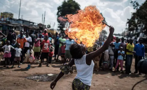 AFP A member of Kenyan acrobat group Kibera Messenger breathes fire during a performance for filming in Kibera, Nairobi, on March 7, 2018.
