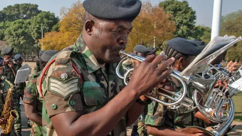 Amos Gumulira / AFP A soldier plays the trumpet in a military band to mark the official start of the upcoming electoral period ahead of next year's elections march in Lilongwe, Malawi - Friday, August 2, 2024