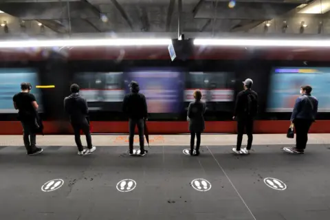 Reuters People stand on markers on a tramway platform