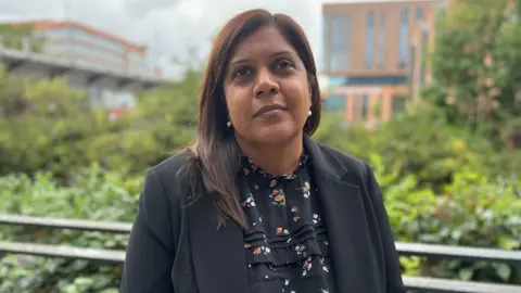 A woman in a dark shirt and jacket