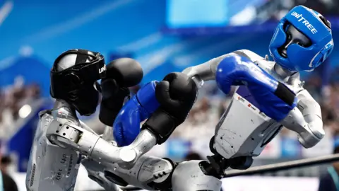 Humanoid robots by Unitree Robotics compete in the 80 kg class kickboxing quarterfinals during the 2026 World Humanoid Robot Games, at the National Speed Skating Oval, in Beijing, China August 23, 2026.
