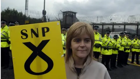 PA Nicola Sturgeon, MSP with a placard during an anti-nuclear campaign attempt to blockade the Faslane nuclear submarine base on the Clyde, Scotland