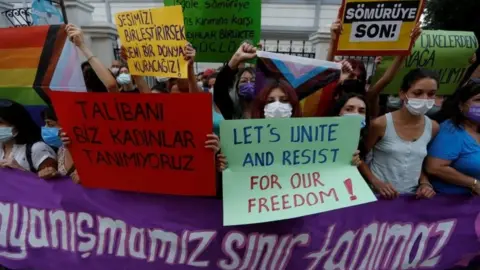 Reuters Activists hold placards saying "Our solidarity no boundaries" and "We, women don't recognise the Taliban" at a protest following the Taliban's takeover of Afghanistan, in Istanbul, Turkey (20 August 2021)