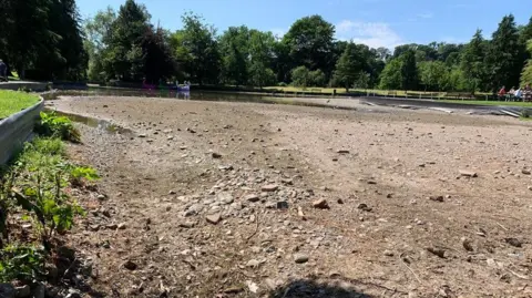 A large expanse of rubble across where once there was a boating pond