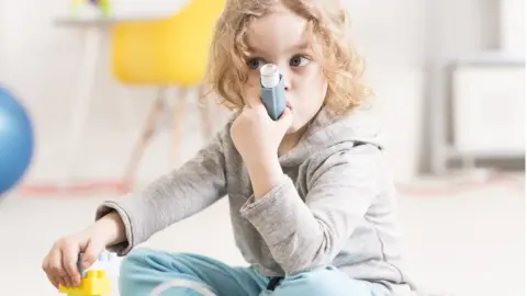 Getty Images Girl using asthma inhaler