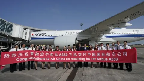 Getty Images Air China staff standing in front of a new Airbus plane