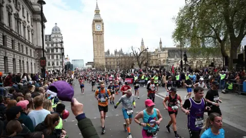 Runners run past Big Ben during the 2024 London marathon