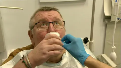 A man swallows a pill containing a balloon in hospital.