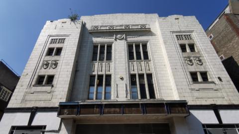 Front of the building at 21 Hobson Street, white facade is slightly discoloured and the old cinema sign is removed