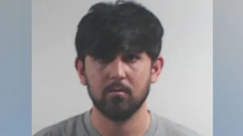 A police mugshot of a bearded Rapualla Ahmadze looking at the camera.