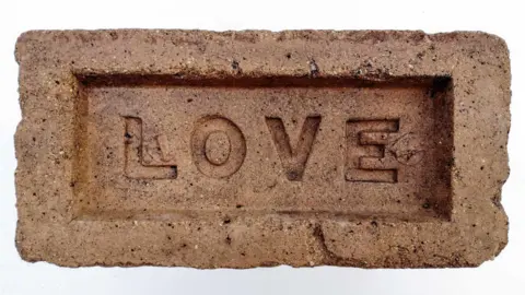 Chris Tilney Brick with LOVE stamped on it